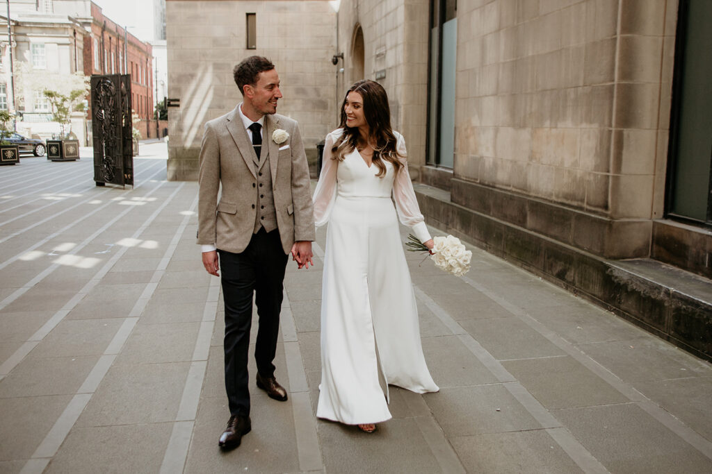 Bride and groom walking hand in hand who decided to elope in the UK