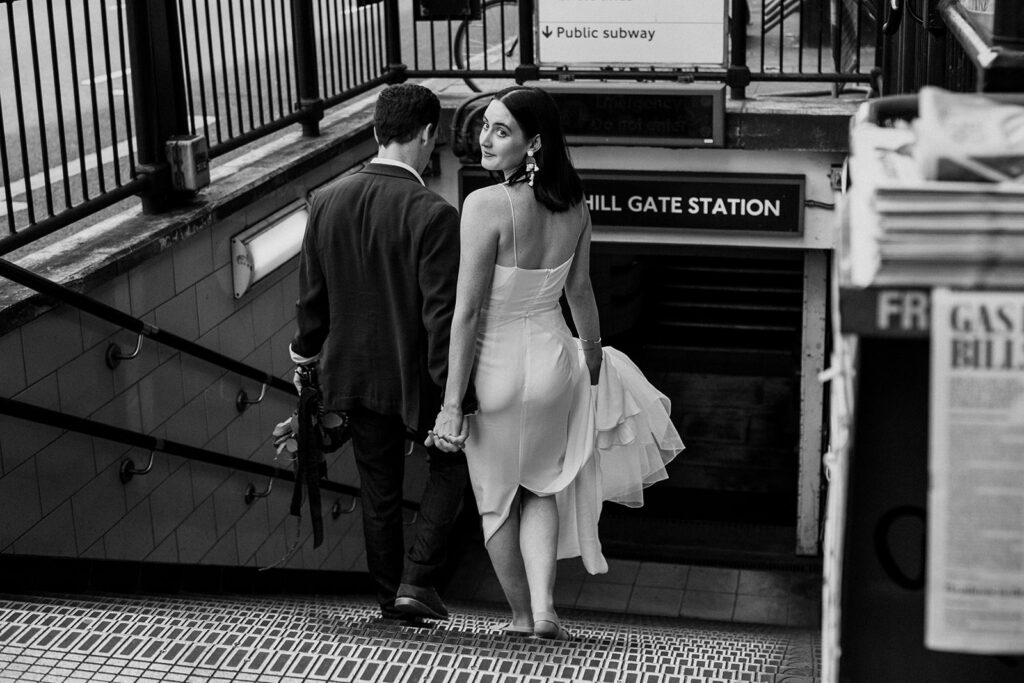 Bride and groom walking hand in hand at tube station who decided to elope in the UK