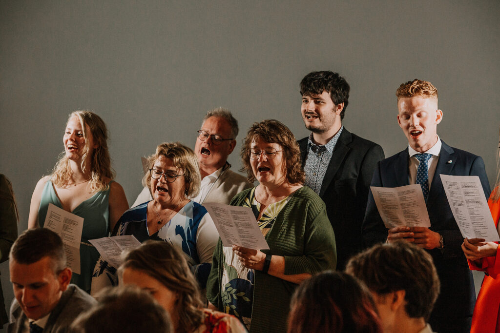 guests sing a song during wedding ceremony