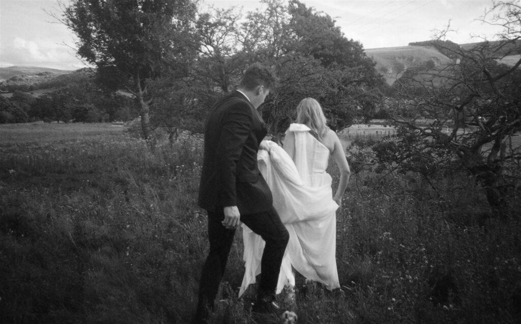 A couple walking through the fields during their wedding photos captured on 35mm film